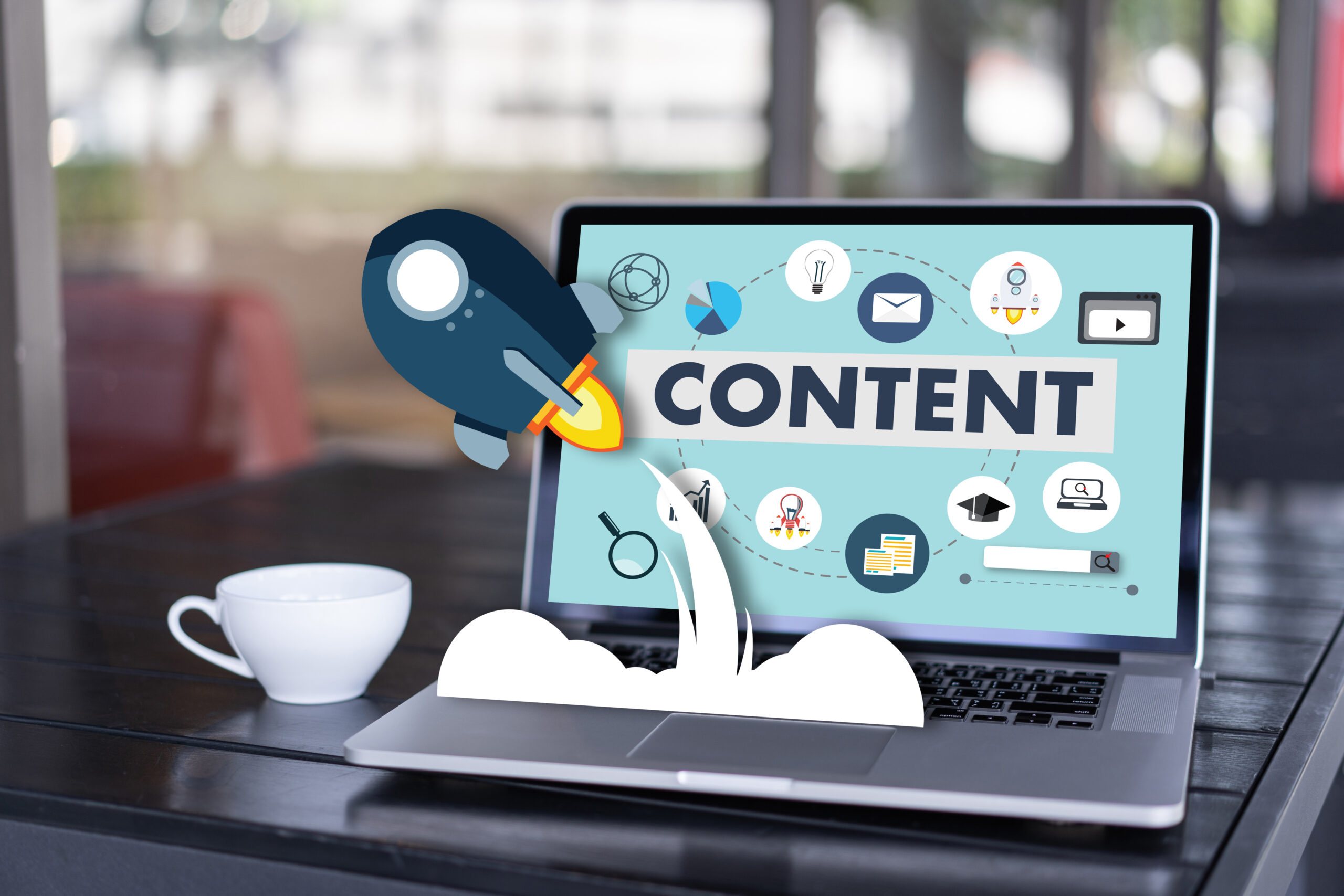 Clipart style images of a coffee cup and rocket ship emerge from an open laptop. The word content is seen on the screen to convey that the user is researching content marketing.